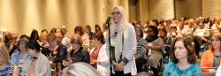 Woman in hijab speaking in a microphone during a conference event